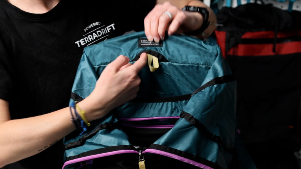 The inside of the Gossamer Gear Loris 25 backpack: hose exit, reservoir sleeve and interior zippered pocket.