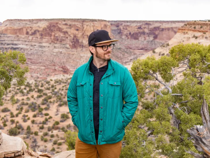 A man stands in front of a canyon in a Stio shirt jacket.