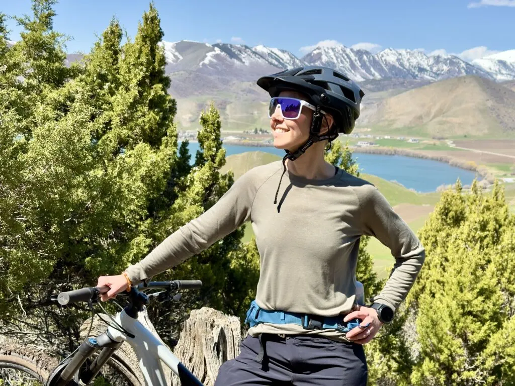 A woman on a bike wears the Freefly Bamboo Lightweight Long Sleeve.