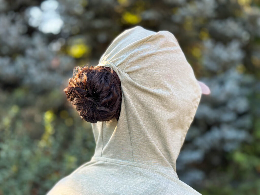 The back of the hood with the ponytail port on the straight hem REI Co-op Sahara Shade Hoodie.