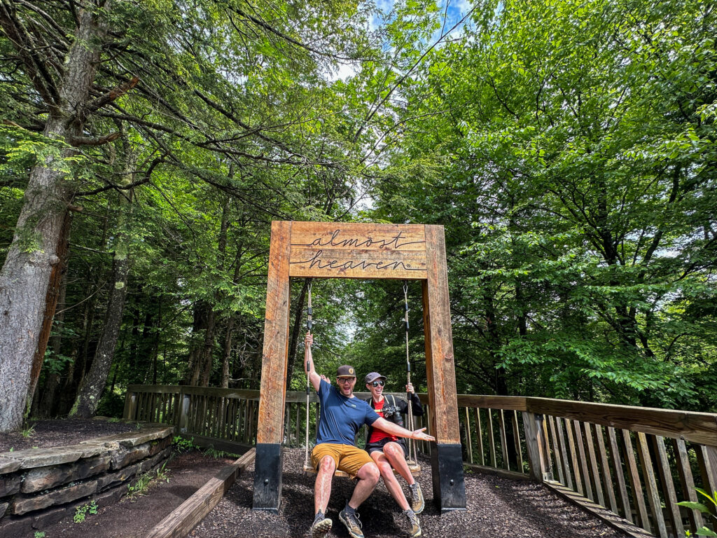 A couple sits on an Almost Heaven swing in Blackwater Falls State Park.