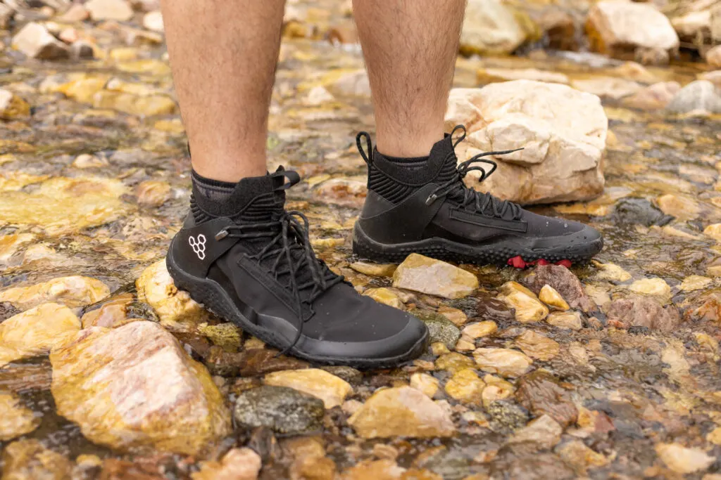 Vivobarefoot Magna Lite WR SG barefoot hiking boot crossing a shallow creek.