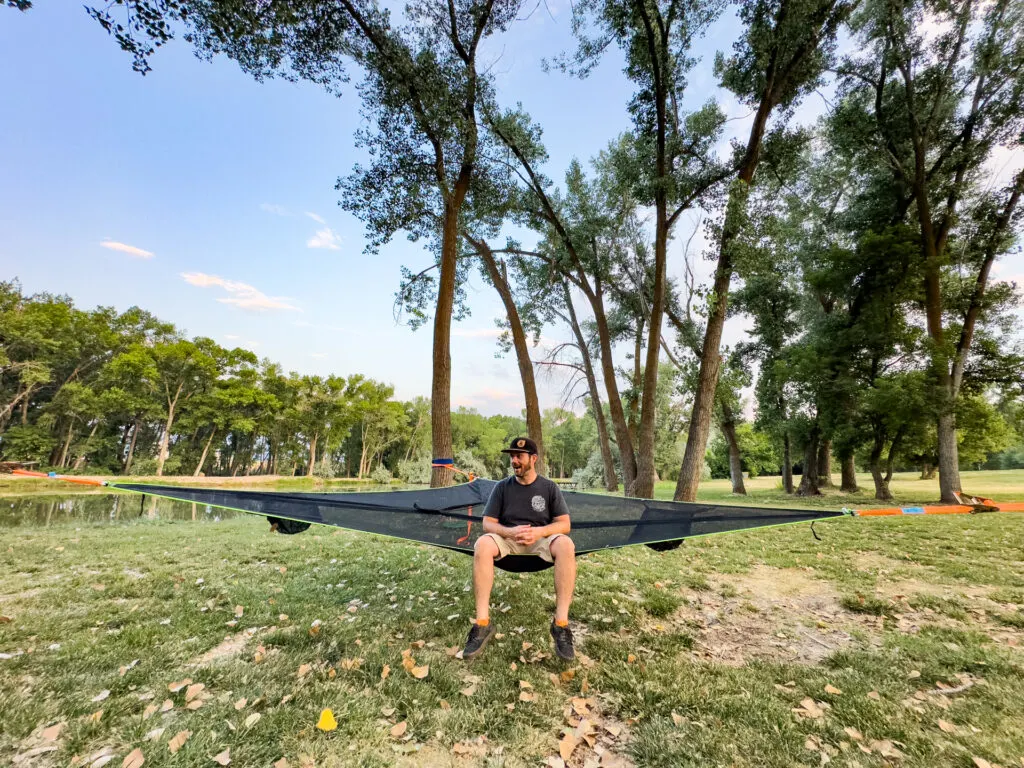 Josh sitting in the Tensile Trillium Mesh lay-flat hammock.