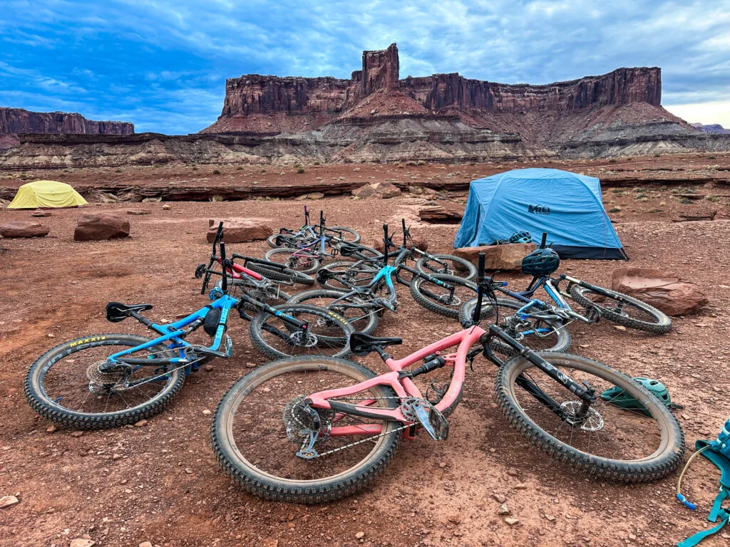 Bikes laying on their sides in front of tents at a dispersed campsite in Canyonlands.