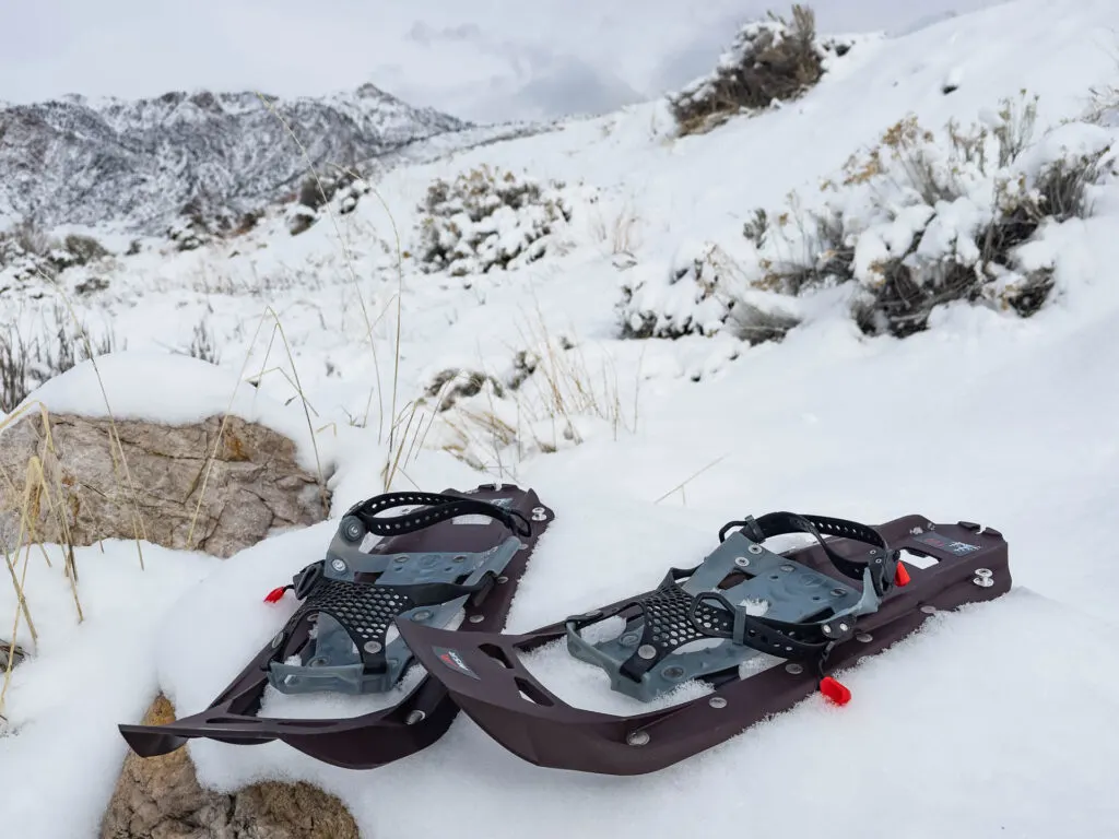 MSR Evo Trail Snowshoes sitting unworn in the snow in front of mountains.