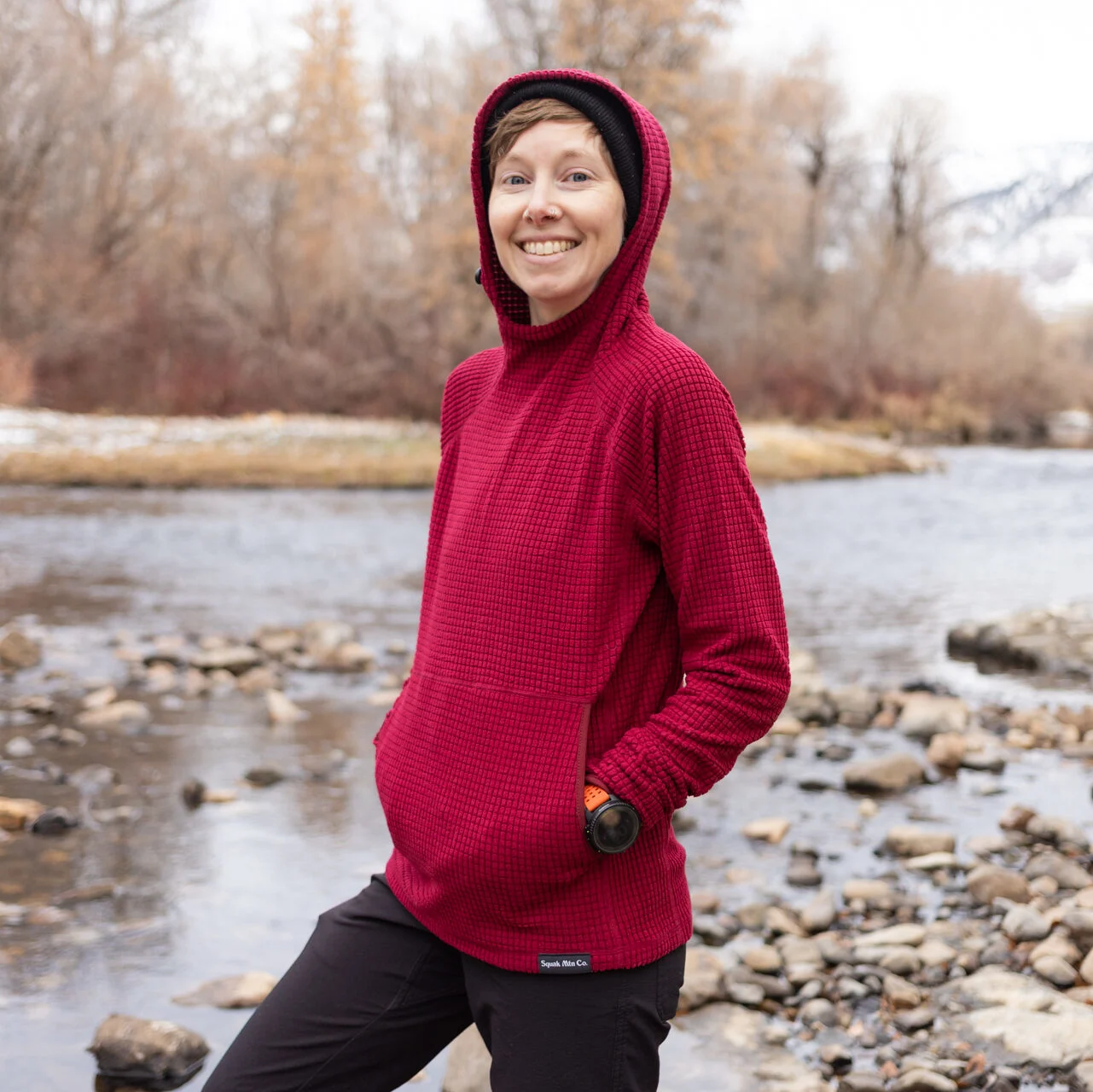 A woman wears a Squak grid hoodie.