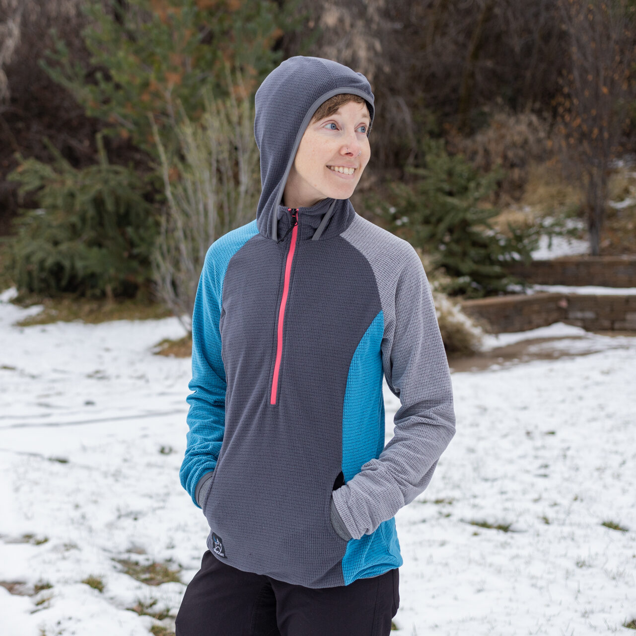 A woman in a SkyGOAT quarter zip grid fleece with hood.