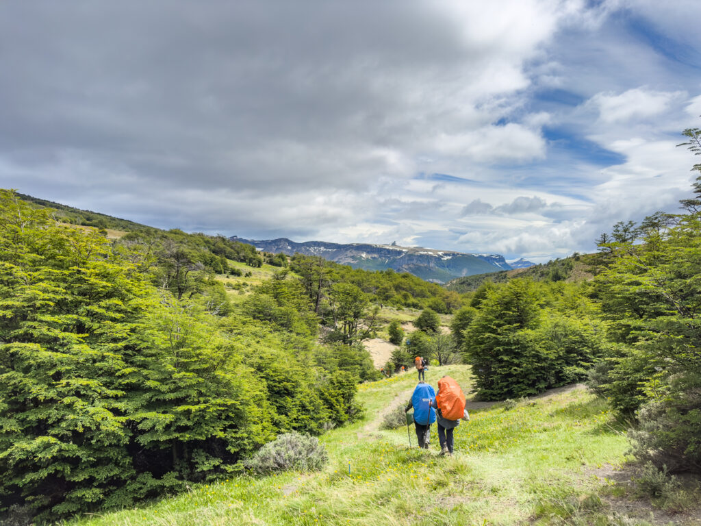 Hiker descend a hill through a field during the Fjällräven Classic Chile.