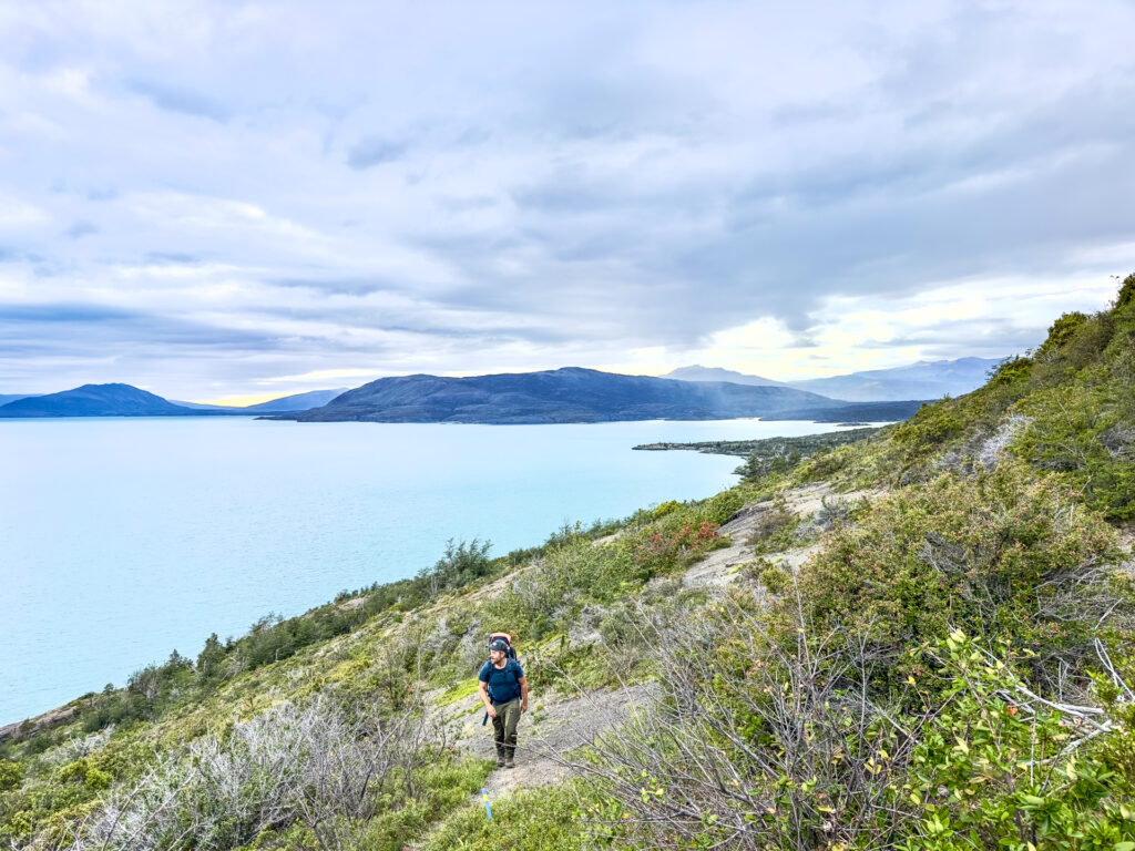 A man treks next to a lake in Chile.