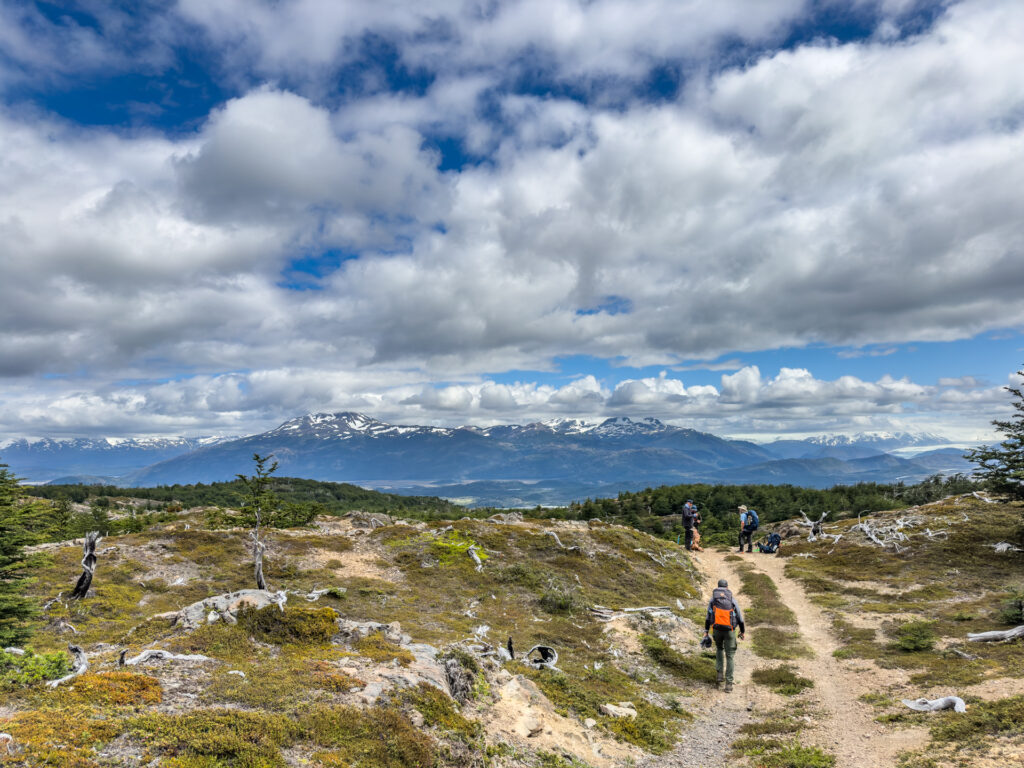 Backpackers on the trail in Patagonia with mountains in the background.