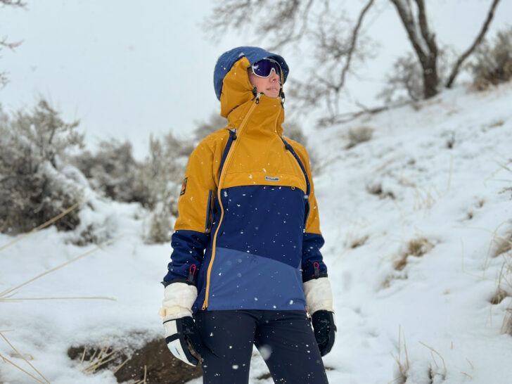 A woman wears a Paramo Velez Evolution Hybrid Smock in the snow.