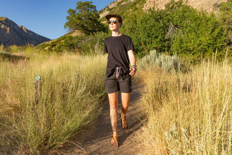 A woman hiking in the late afternoon sun wearing a t-shirt and hiking shorts for women.