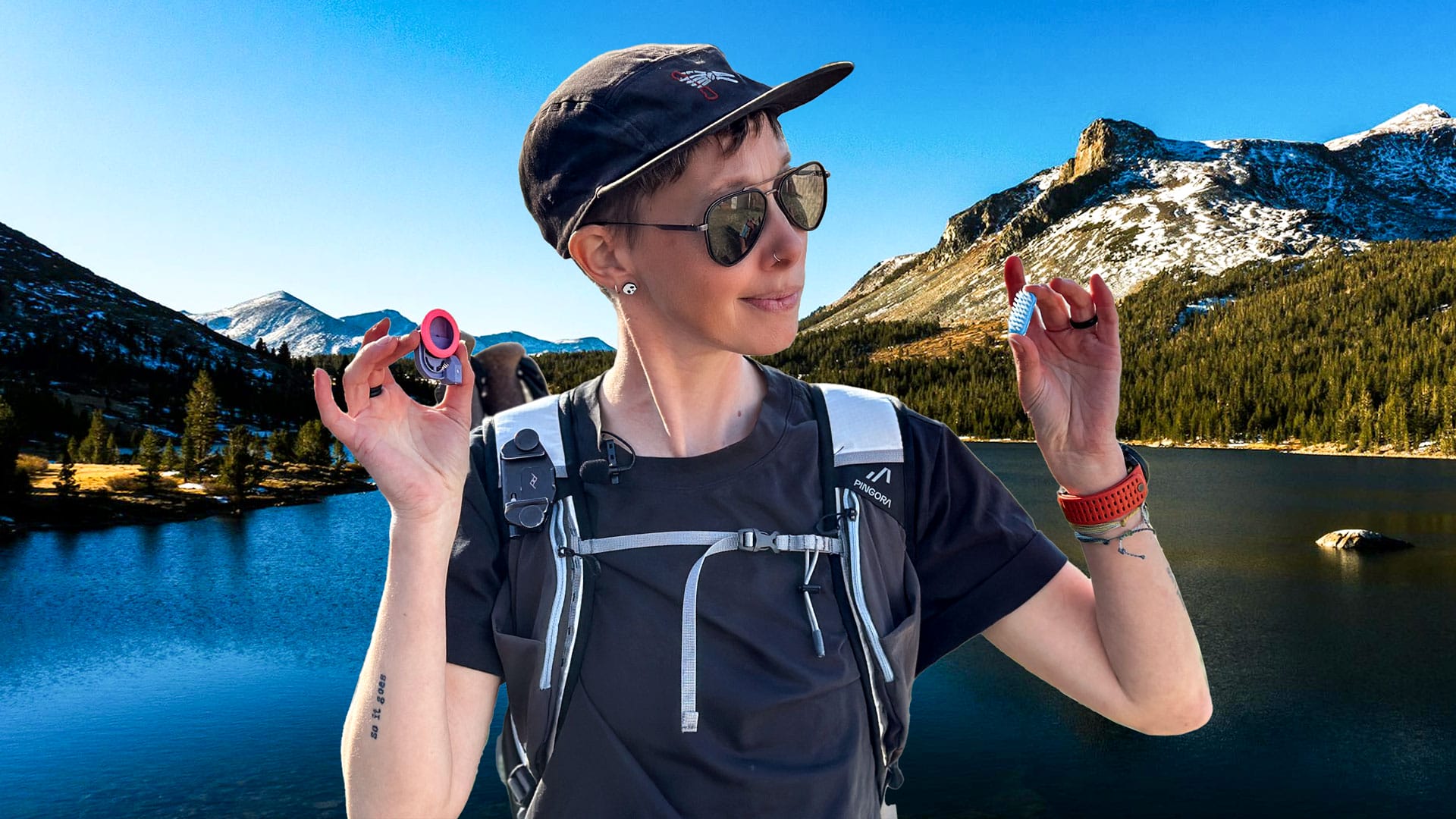 Ultralight backpacking gadgets: Are they worth it? A woman with a backpack stand s in front of mountains holding two small ultralight gadgets and considers them.