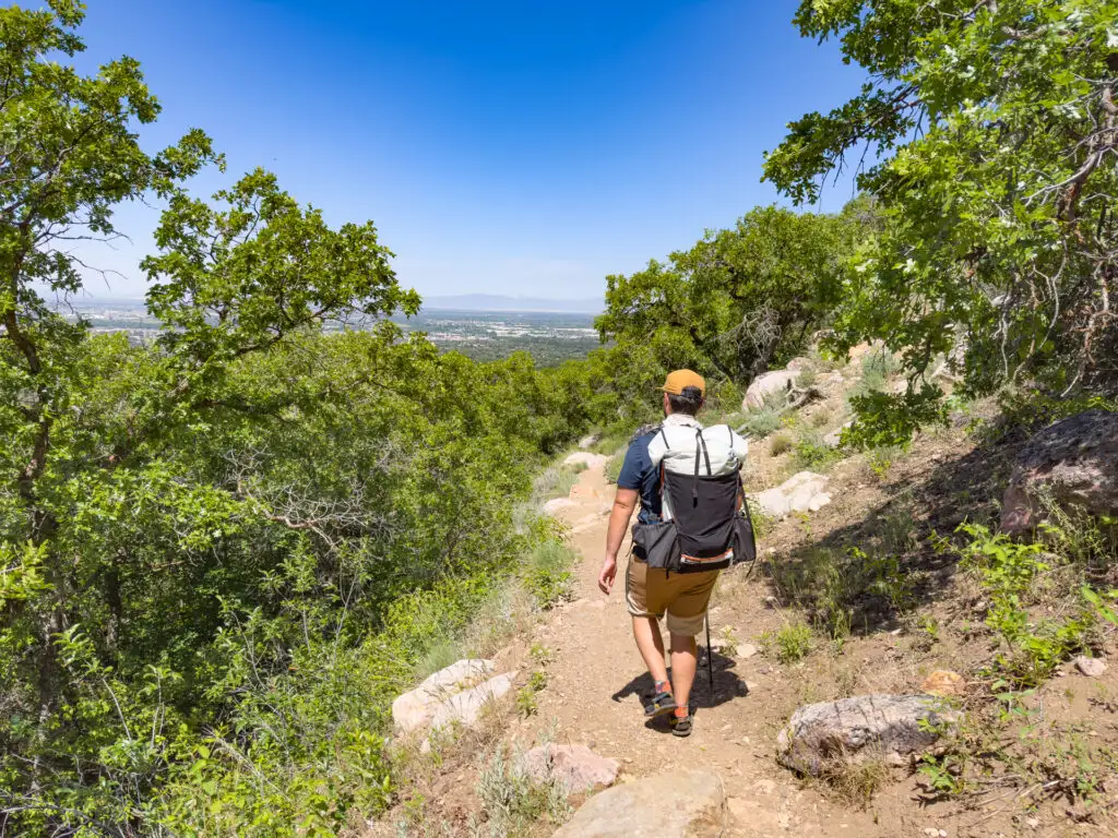 A man hikes on a trail wearing the Hyperlite Mountain Gear Unbound 55 Backpack.
