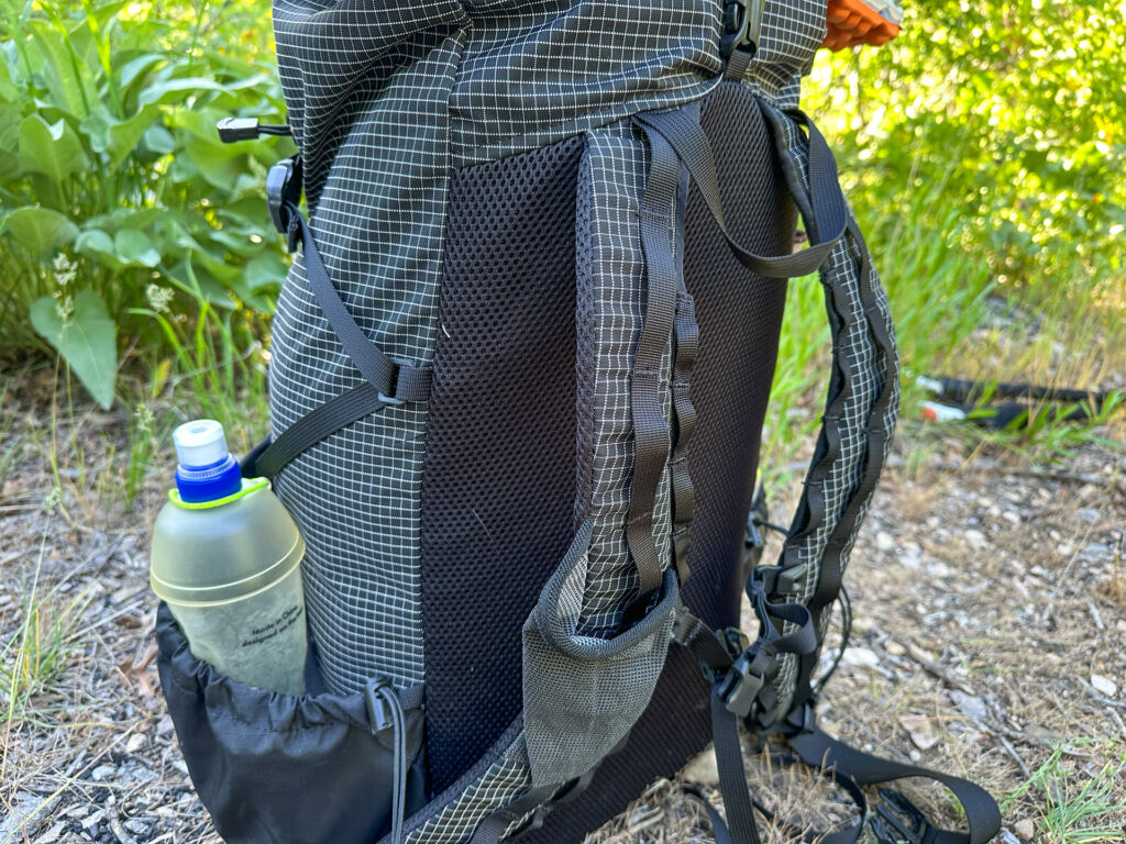 A close up of the large water bottle pockets, S-curve straps with lots of daisy chains, and mesh back panel on the Symbiosis Gear Aspen backpack.