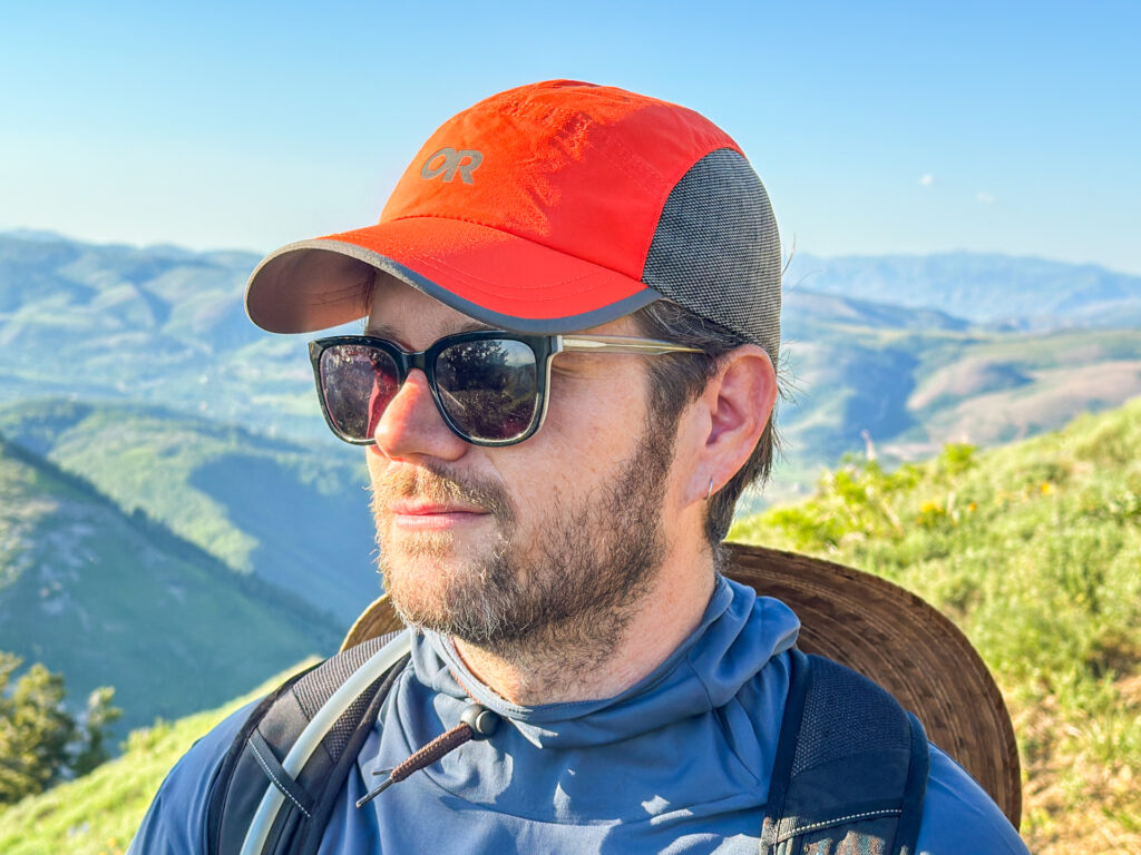 A man wears the Outdoor Research Swift Cap while hiking.