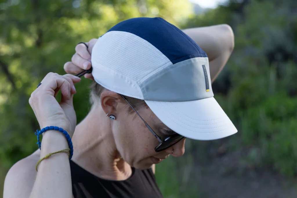 A woman adjusts the Ciele FST Cap.