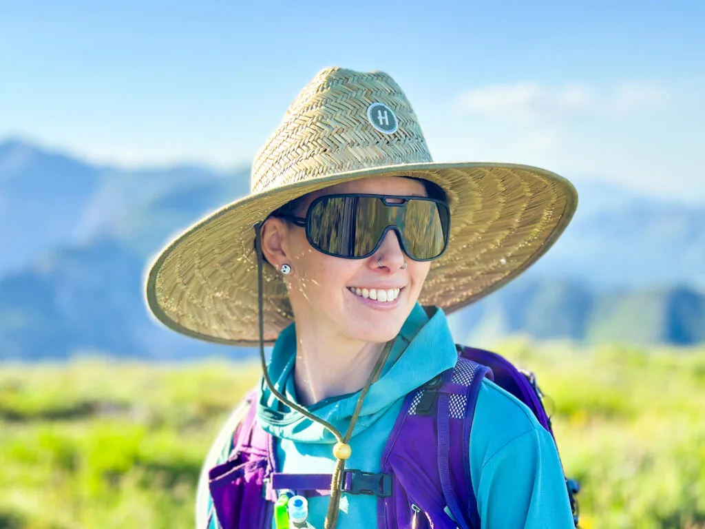 A woman wears the Hemlock Lifeguard Hat while hiking.
