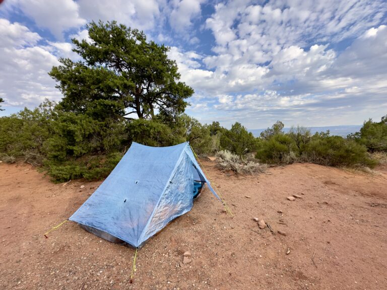 A blue Zpacks tent pitched in the desert.