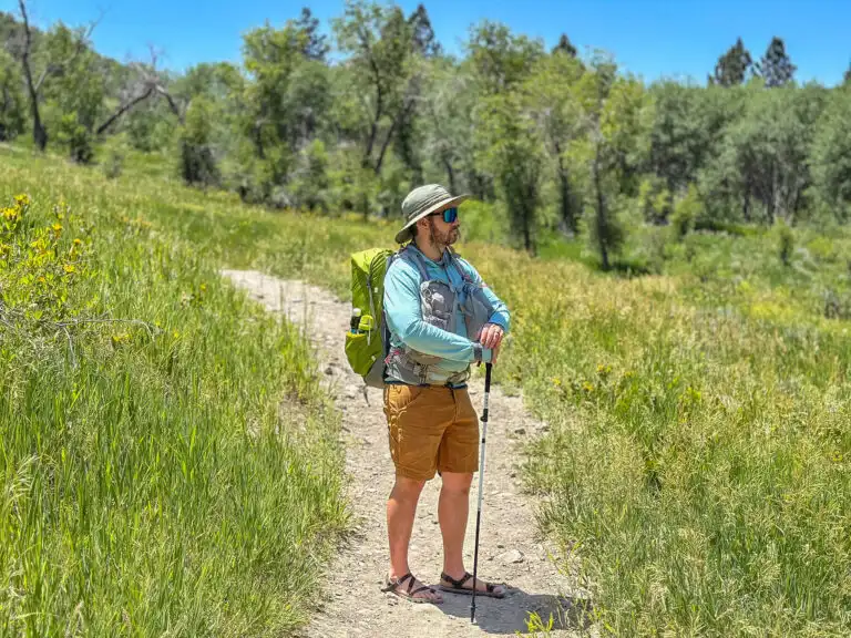 A man stands on a trail with an Aarn Featherlite Freedom Backpack.