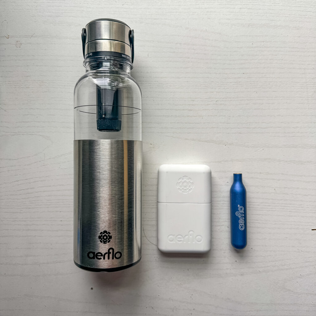 The Aerflo System Bottle with cartridge case and a cartridge next to it.
