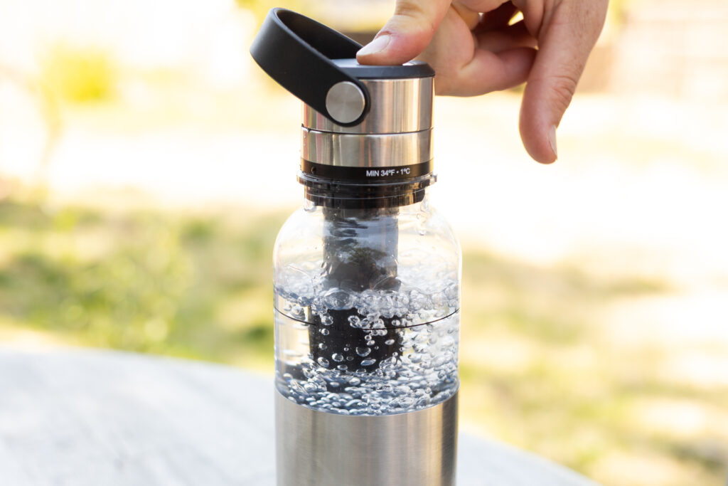 Bubbles in the Aerflo bottle as a finger depresses the button to vent and carbonate.
