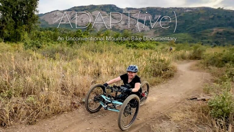 A woman rides an adaptive mountain bike on a trail.