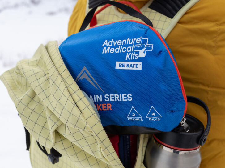 A first aid kit sticks out of a backpack.