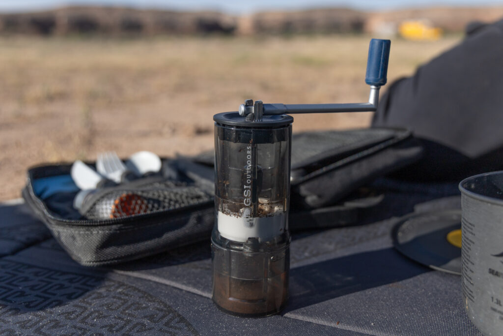 The GSI JavaGrind sits on a mat with other camping supplies.
