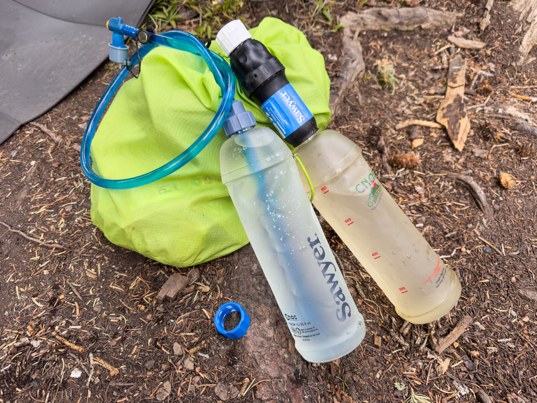 Two CNOC reusable bottle and a One Bottle Hydration System hose.