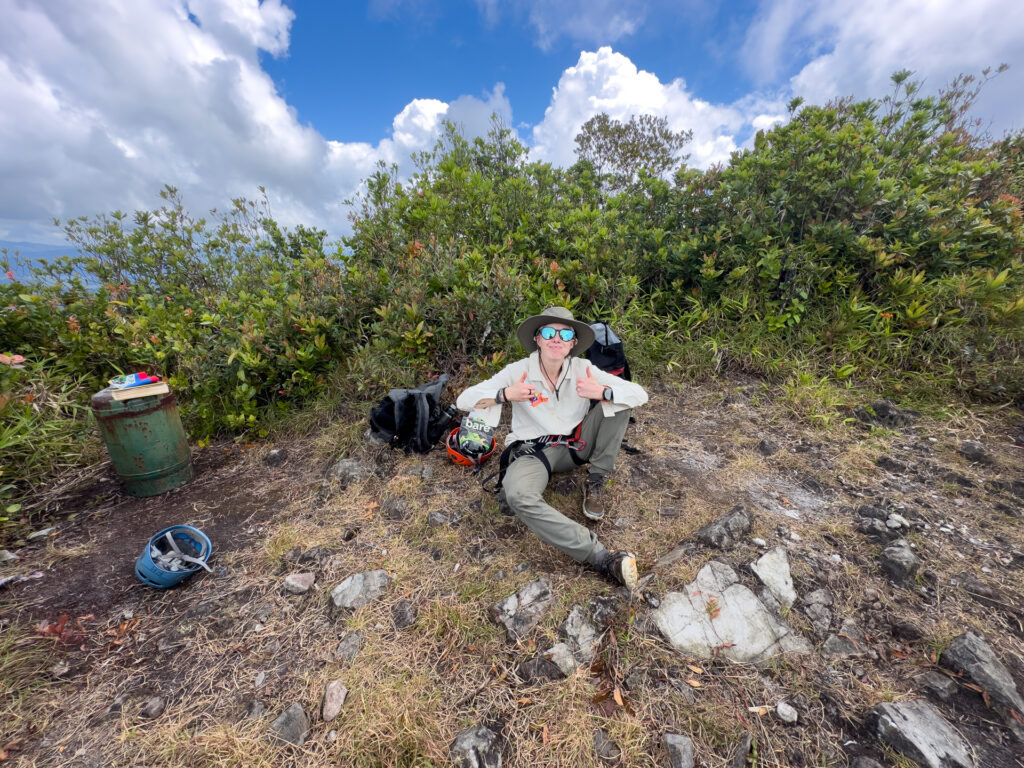 A woman resting at the summit of Victoria Peak in Belize.