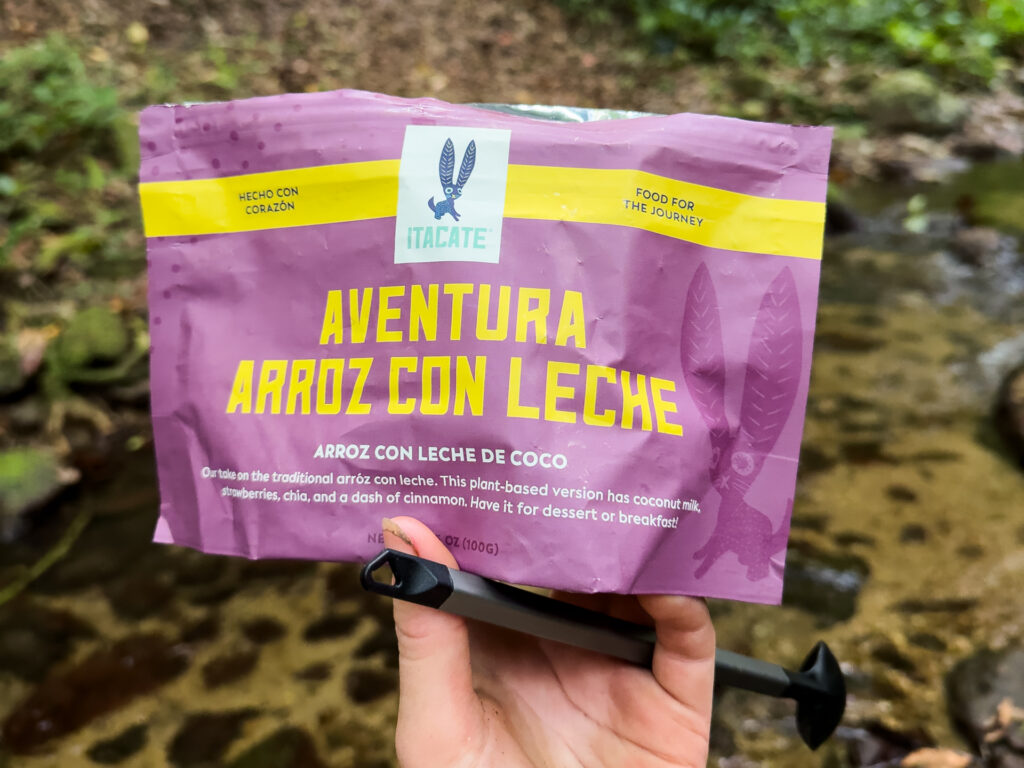A hand holds a dehydrated backpacking meal from Itacate.