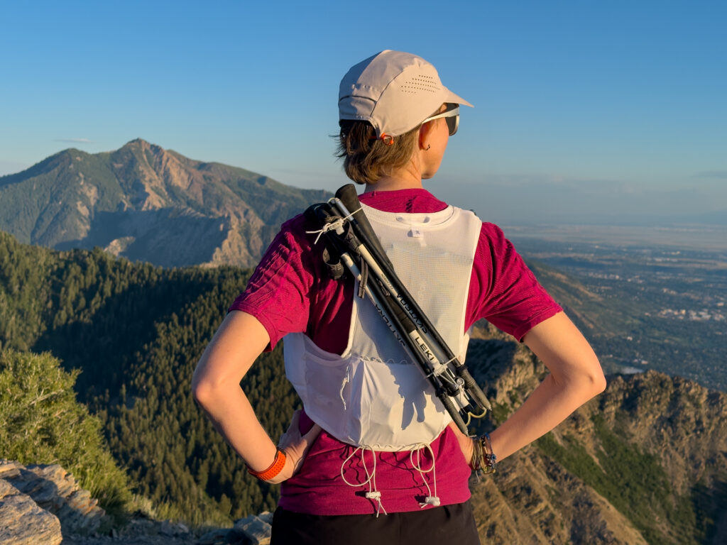 A woman wears the The On Ultra Pro Vest on a trail (rear view).
