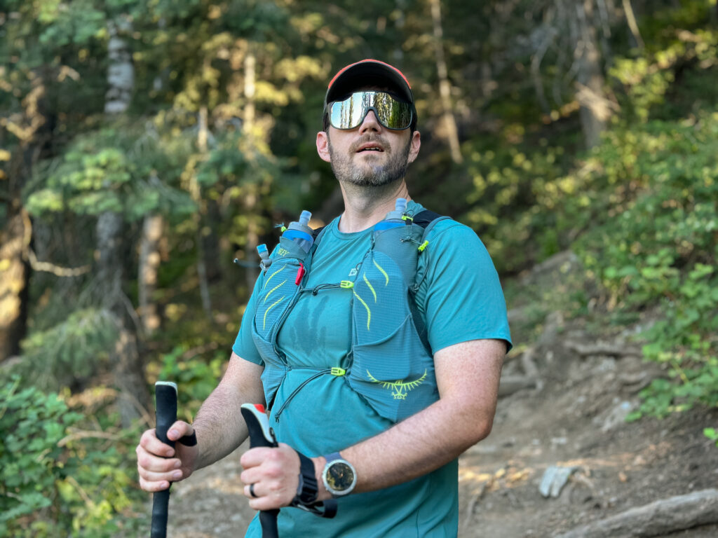 A man wears the Osprey Duro running hydration vest on a trail.
