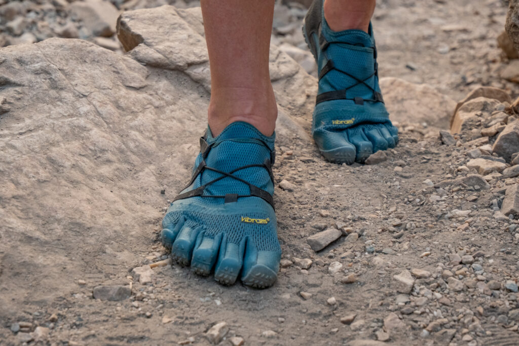 Feet walking n a dirt trail in Vibram Five Finger Spidrwalk shoes.
