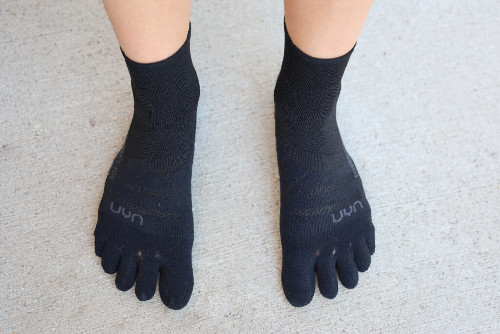 A pair of feet in Uyn Runners Five toe socks for hiking and running.