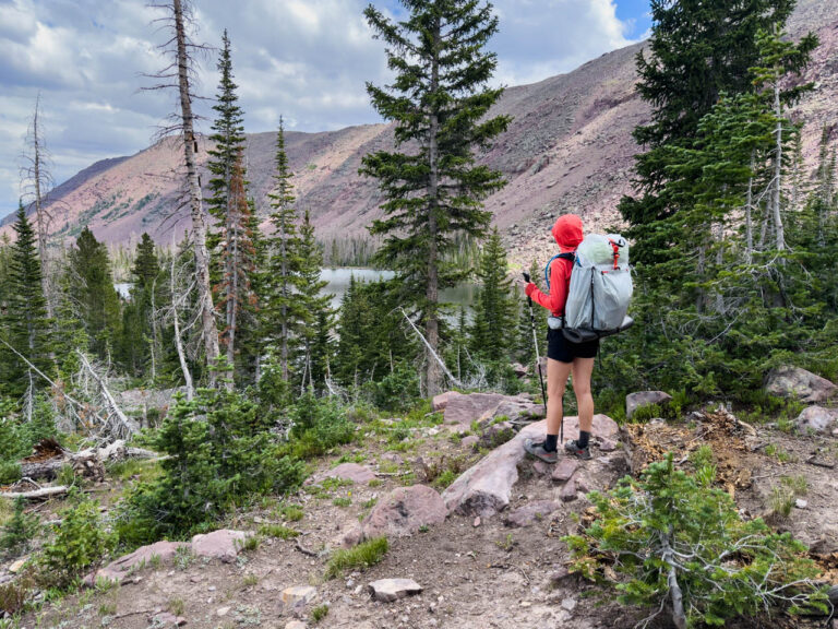 A woman stands at an overlook with the Mountain Hardware Alakazam 45 ultralight backpack.