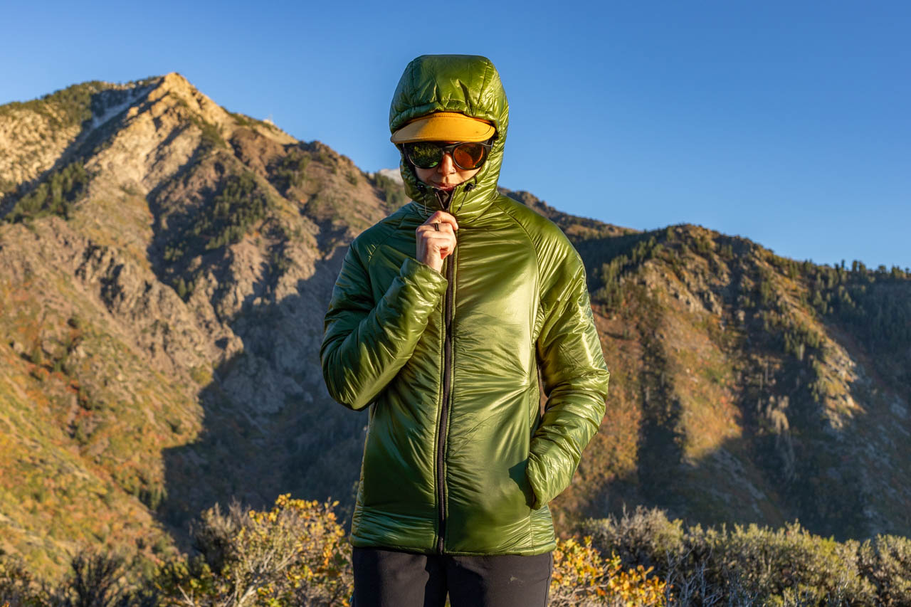 A woman wear an Enlightend Equipment Torrid ultralight insulated jacket on a mountain.