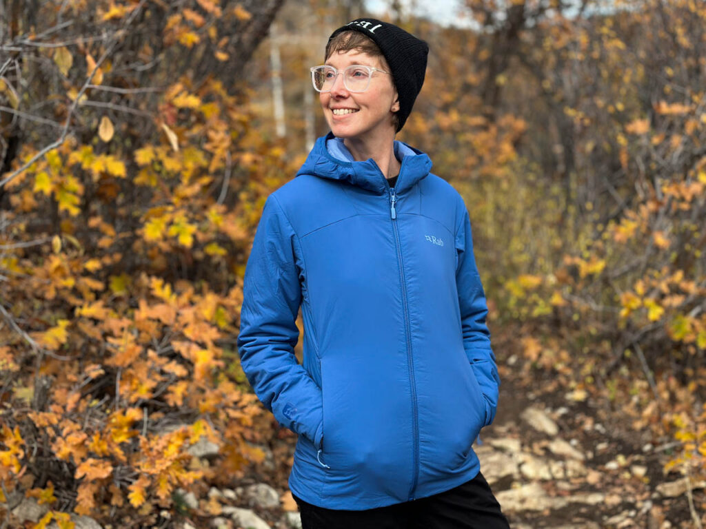 A woman wears a Rab Xenair Alpine Light synthetic jacket.